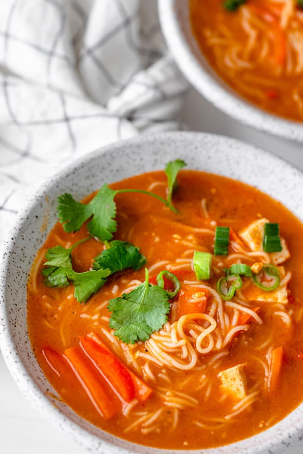 Red noodle soup garnished with fresh coriander 