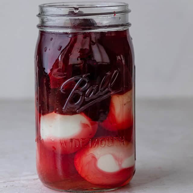 A jar full of hard boiled eggs, beets, and the pickling liquid.