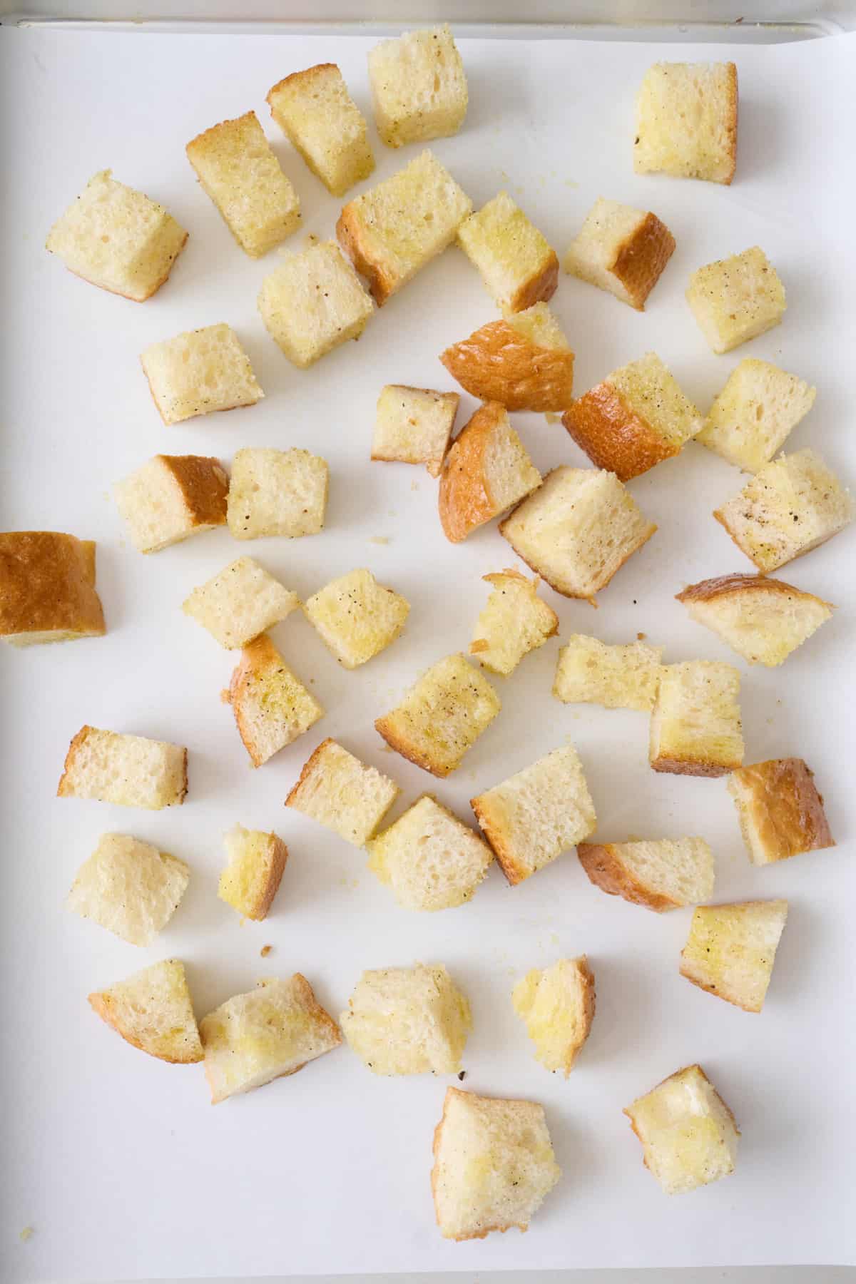 French baguette cubes on a sheet pan.