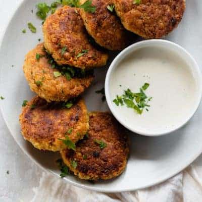 Chickpea fritters on a white plate with a dip