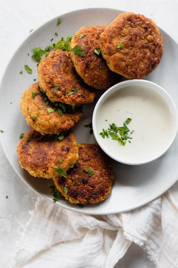 Chickpea fritters on a white plate with a dip