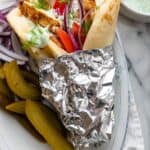 Chicken gyro after grilling served with pickles and tzatziki