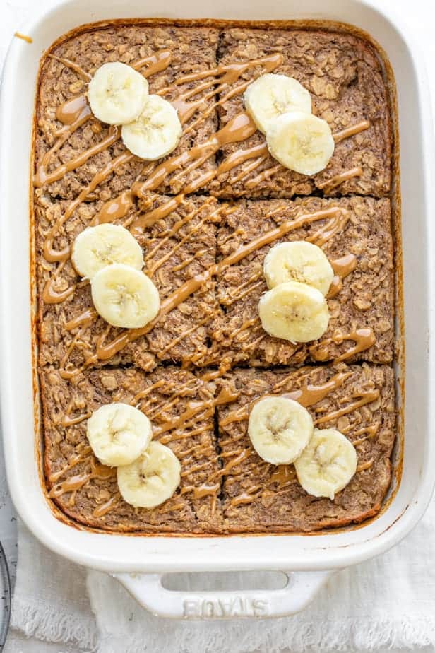 Banana baked oatmeal drizzled with peanut butter and top with banana slices