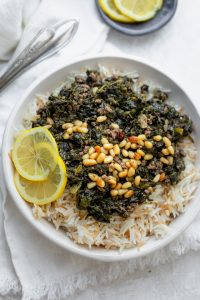 Lebanese Spinach Stew (Sabanekh wu riz) served with pine nuts and lemon slices