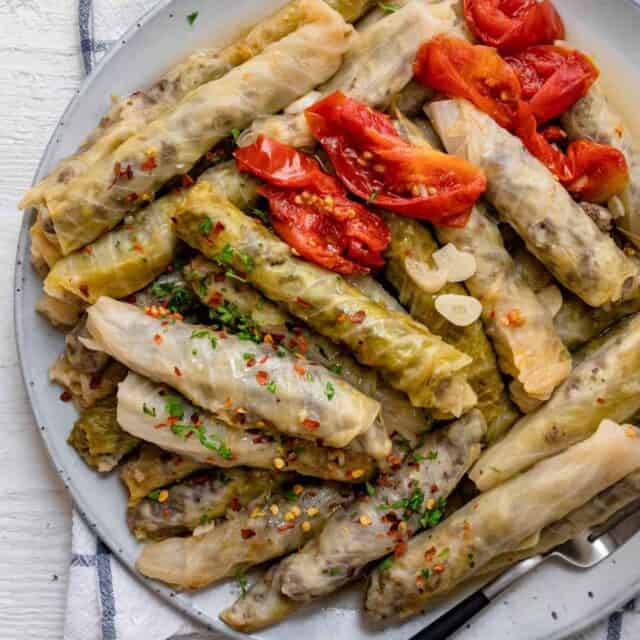 Plate of stuffed cabbage rolls - lebanese style served with tomato slices