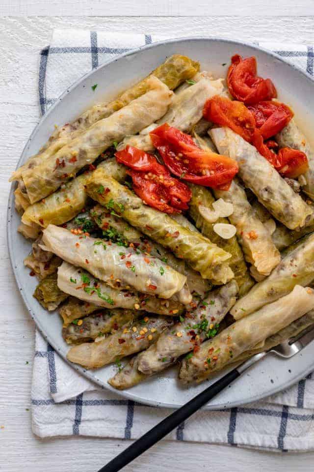 Plate of stuffed cabbage rolls - lebanese style served with tomato slices