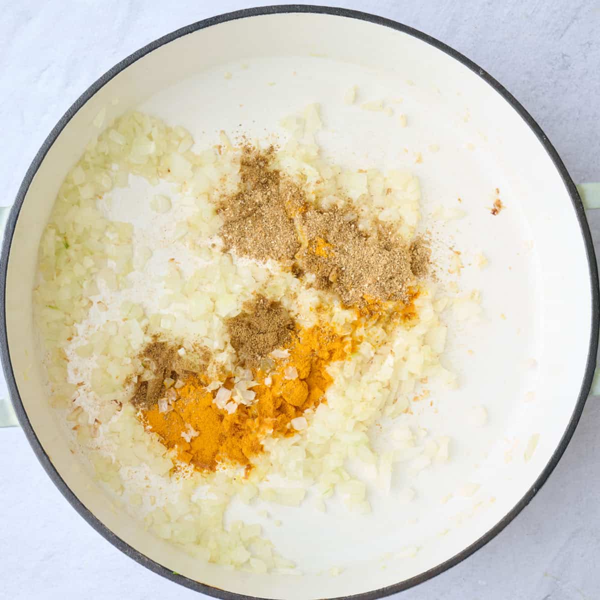 Onion, garlic, ginger, and seasonings in a large pot before tossing together.
