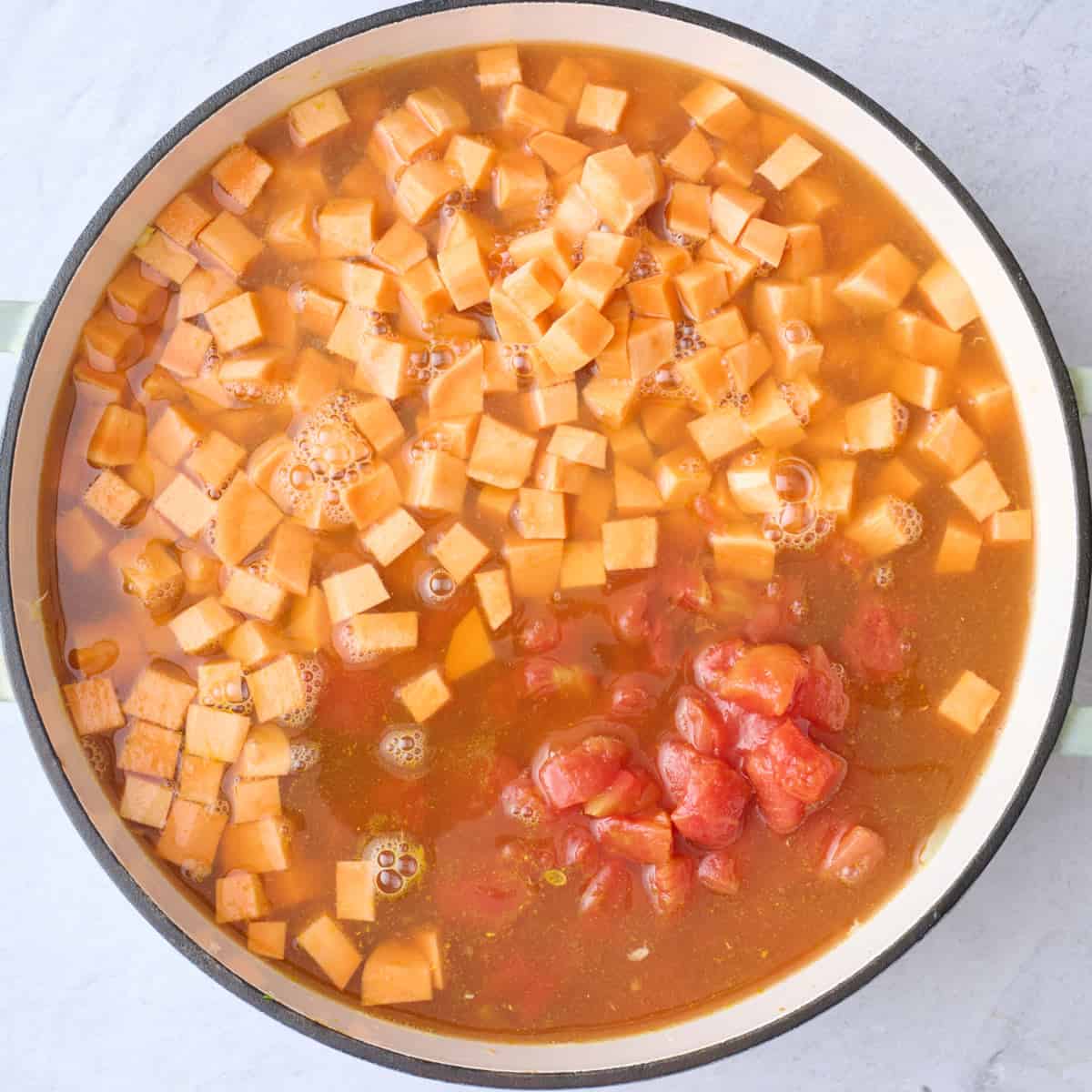 The pot of soup after adding the sweet potatoes, tomatoes, and broth.