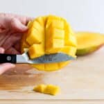 Illustrating the knife method for removing the mango from the skin