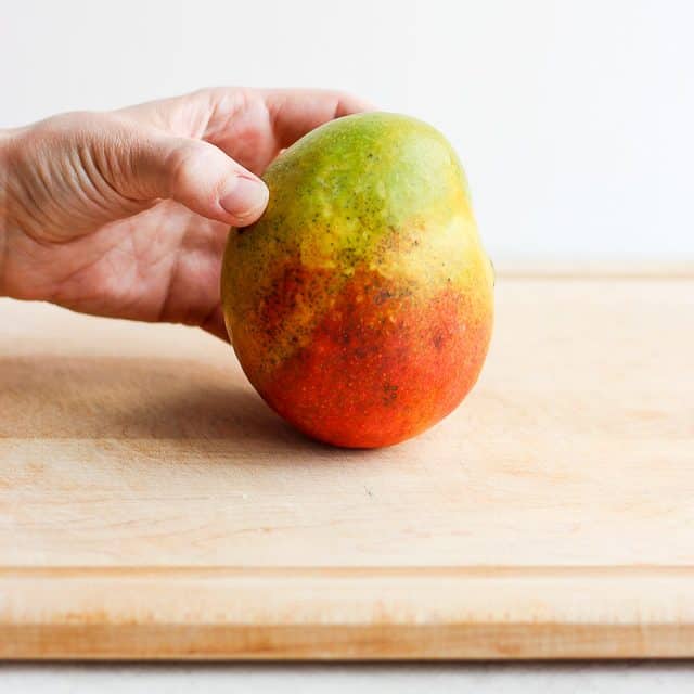 hand holding a mango