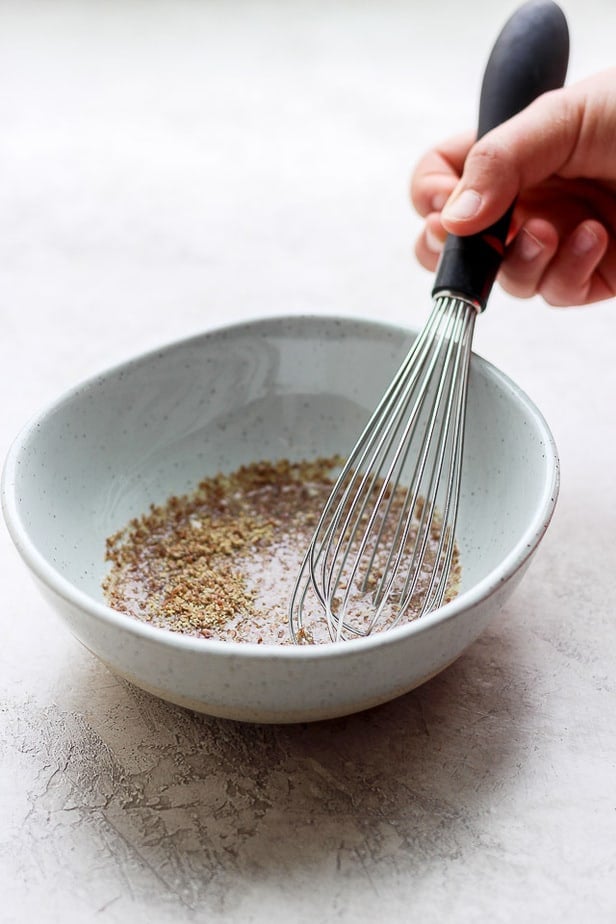 stirring flaxseed in bowl with water