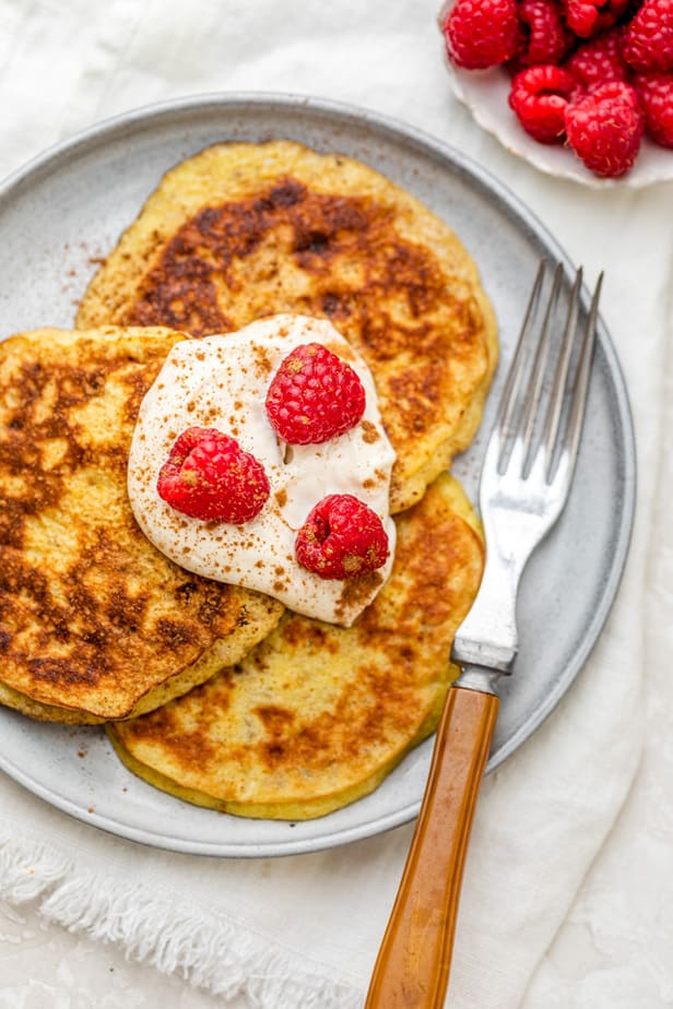 Three pancakes on a plate served with a fork