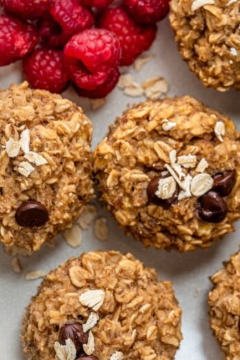 Banana oatmeal cups on a dish with raspberries.