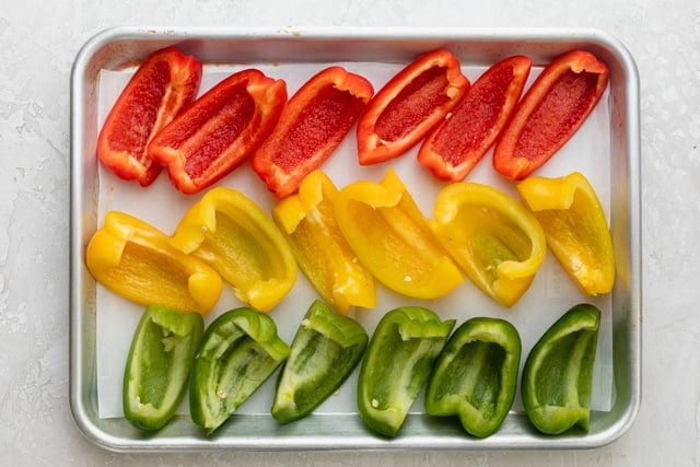 Slices of bell pepper on a baking sheet