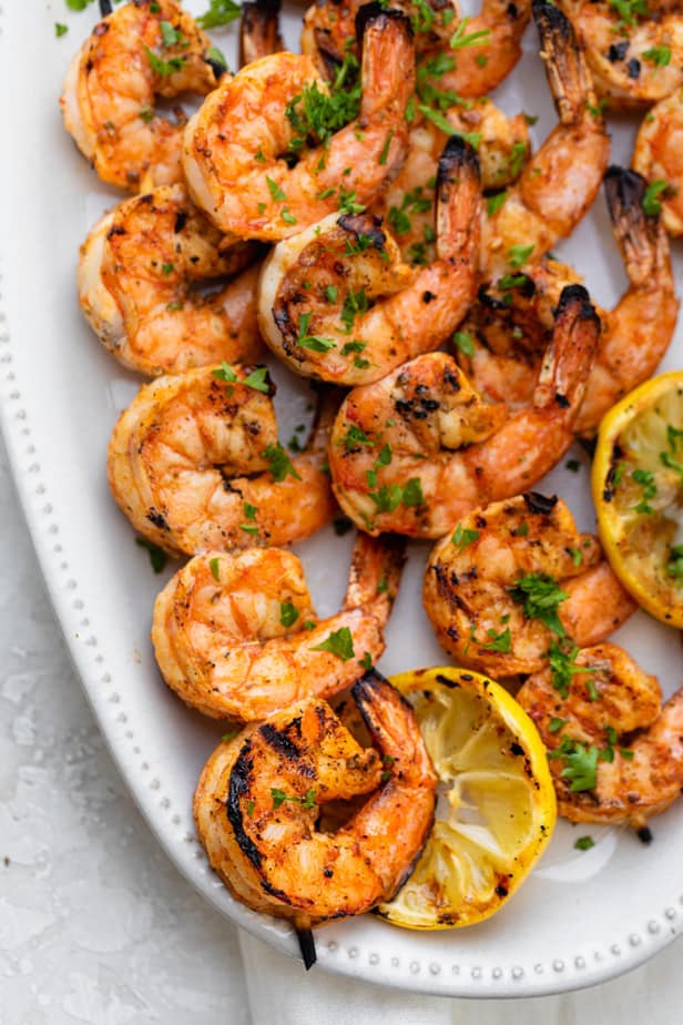 Grilled Shrimp Skewers served on a white plate with lemon slices