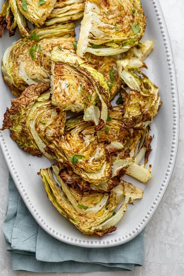 Close up of roasted cabbage steaks on a white plate