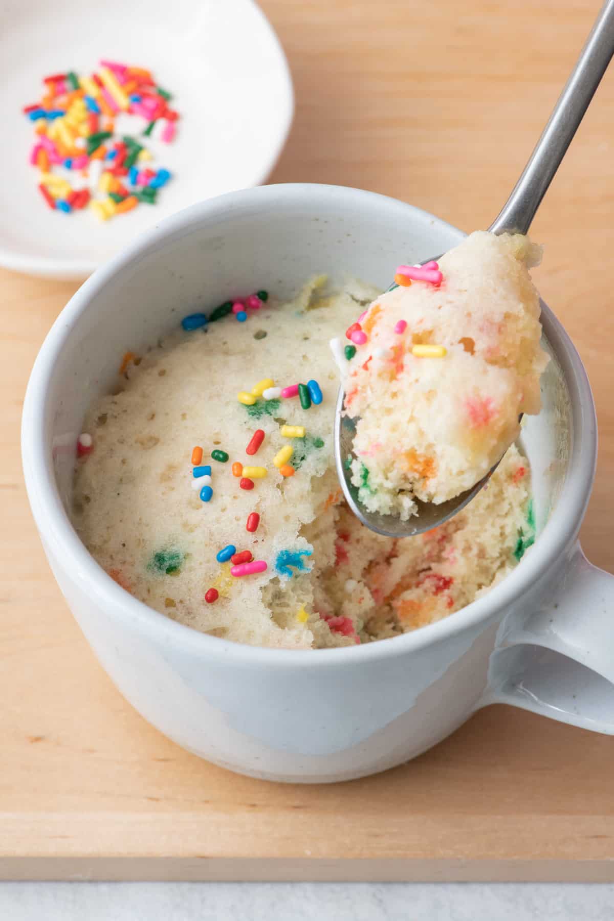 Spoon scooping out a bite of vanilla mug cake.