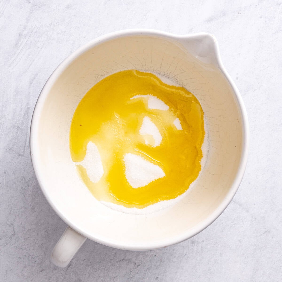 Oil and sugar in a bowl before whisking.