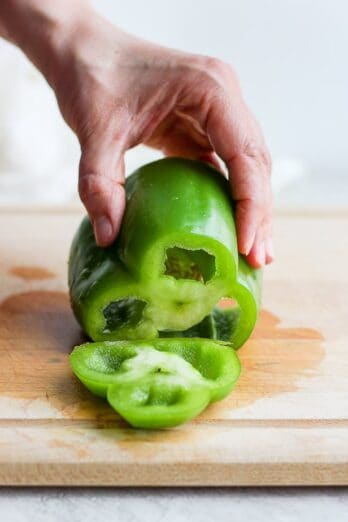 hand holding a green bell peppers
