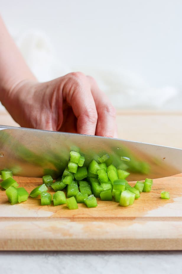 knife dicing a green pepper