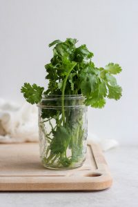 glass jar with cilantro in it