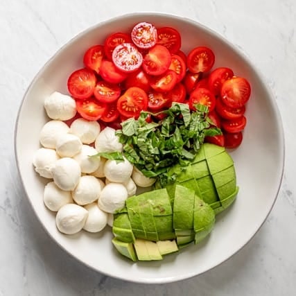 Ingredients for salad in a large bowl.