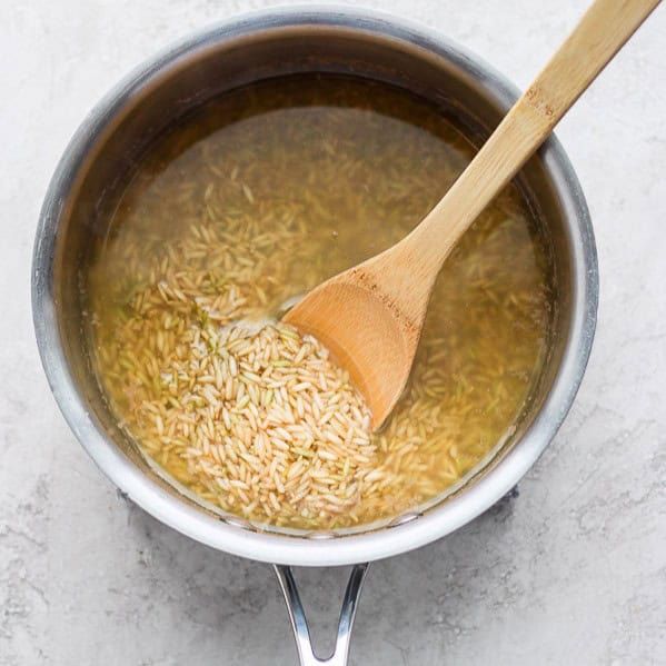 Spoon stirring the pot of rice.