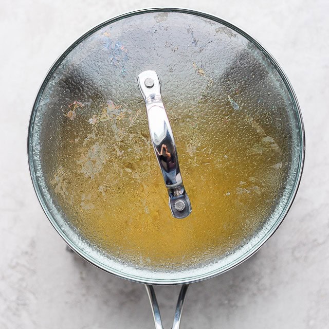 A lid on top of a pot of cooking brown rice.