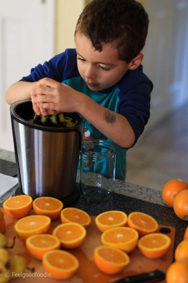 My son juicing oranges with a small citrus juicer