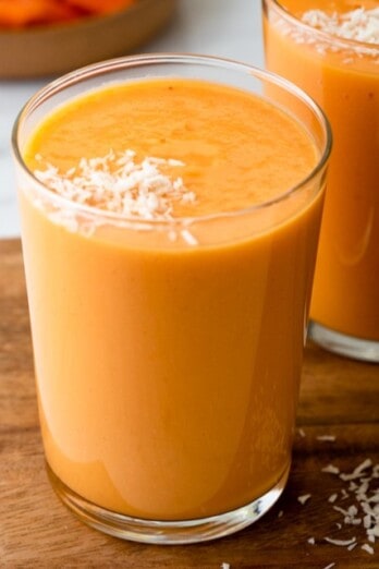 Mango papaya smoothie in a glass with another in the background.
