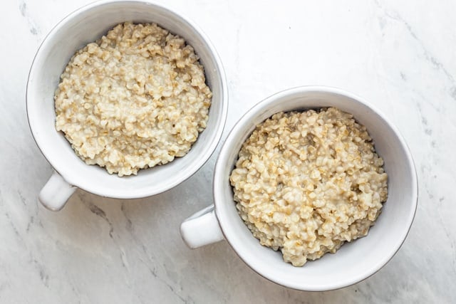 Two mug bowls of cooked steel cut oatmeal