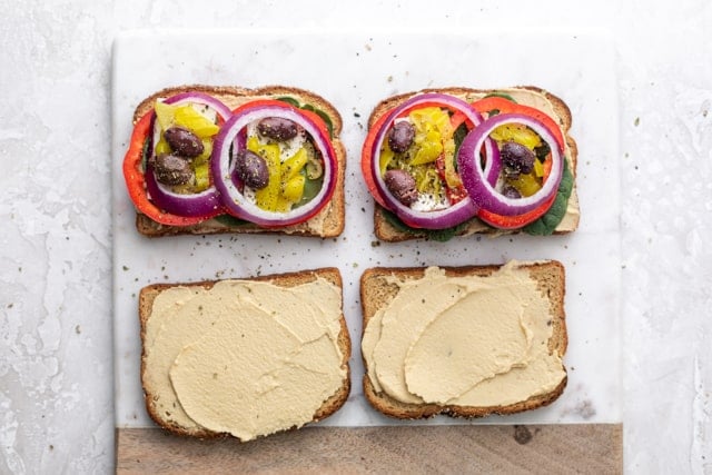 Layering the vegetables on top of hummus