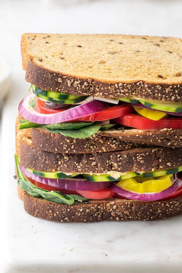 Veggie and hummus sandwich on a marble board