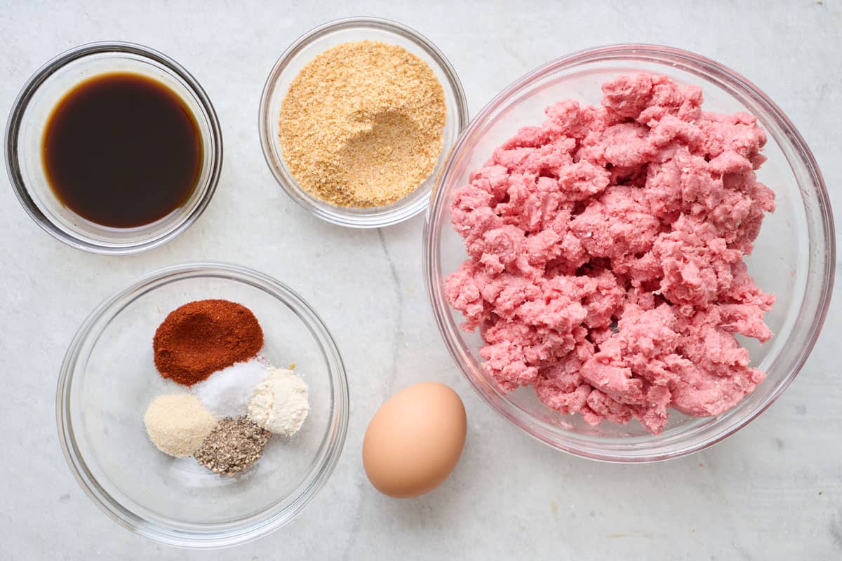 Ingredients for recipe before prepping: Worcestershire sauce, spices, breadcrumbs, an egg, and lean ground beef.
