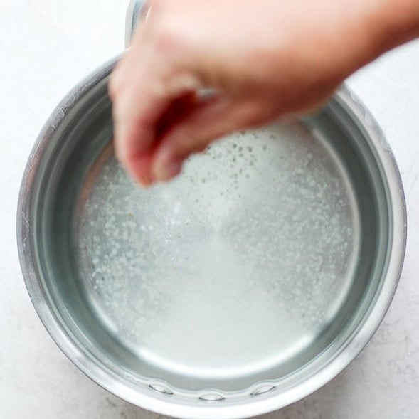 Salting a pot of water.