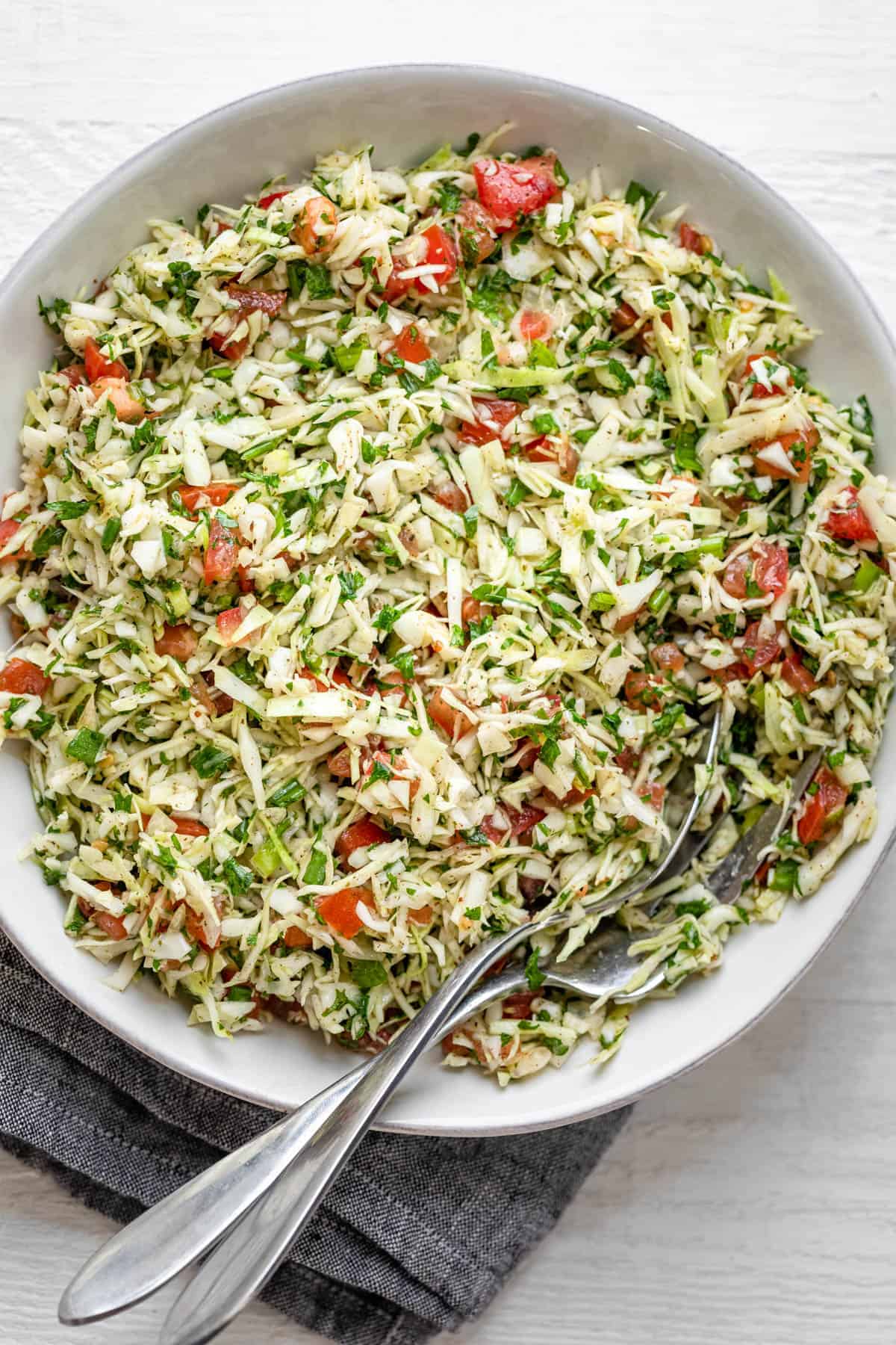 Lebanese Cabbage Salad in a large bowl with lemon slices on the side