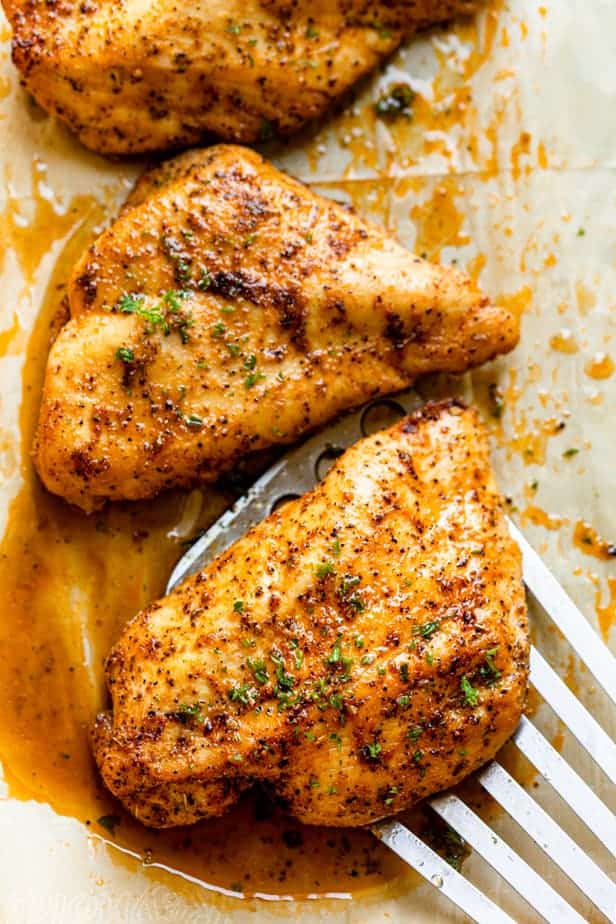 Metal spatula under chicken breast to serve it after cooking in the oven