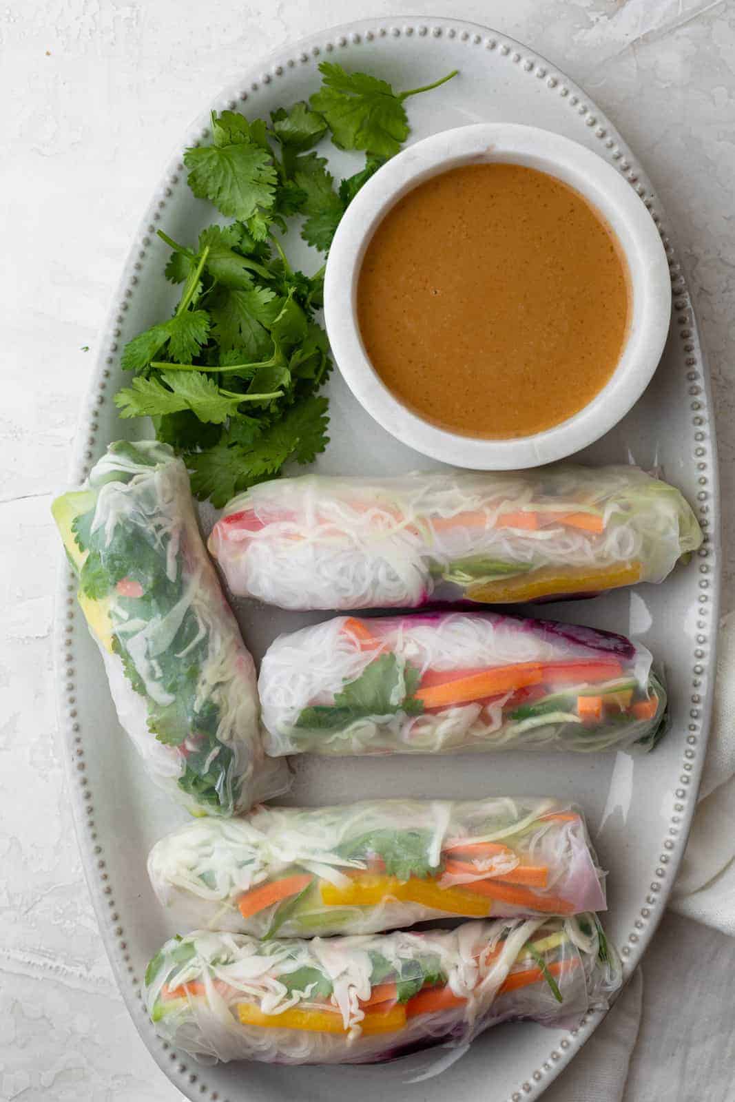 Platter of Vietnamese vegetable spring rolls with peanut dipping sauce