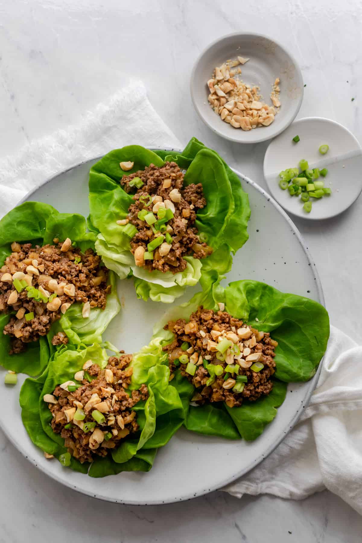 Asian lettuce wraps serve with peanuts and green onions