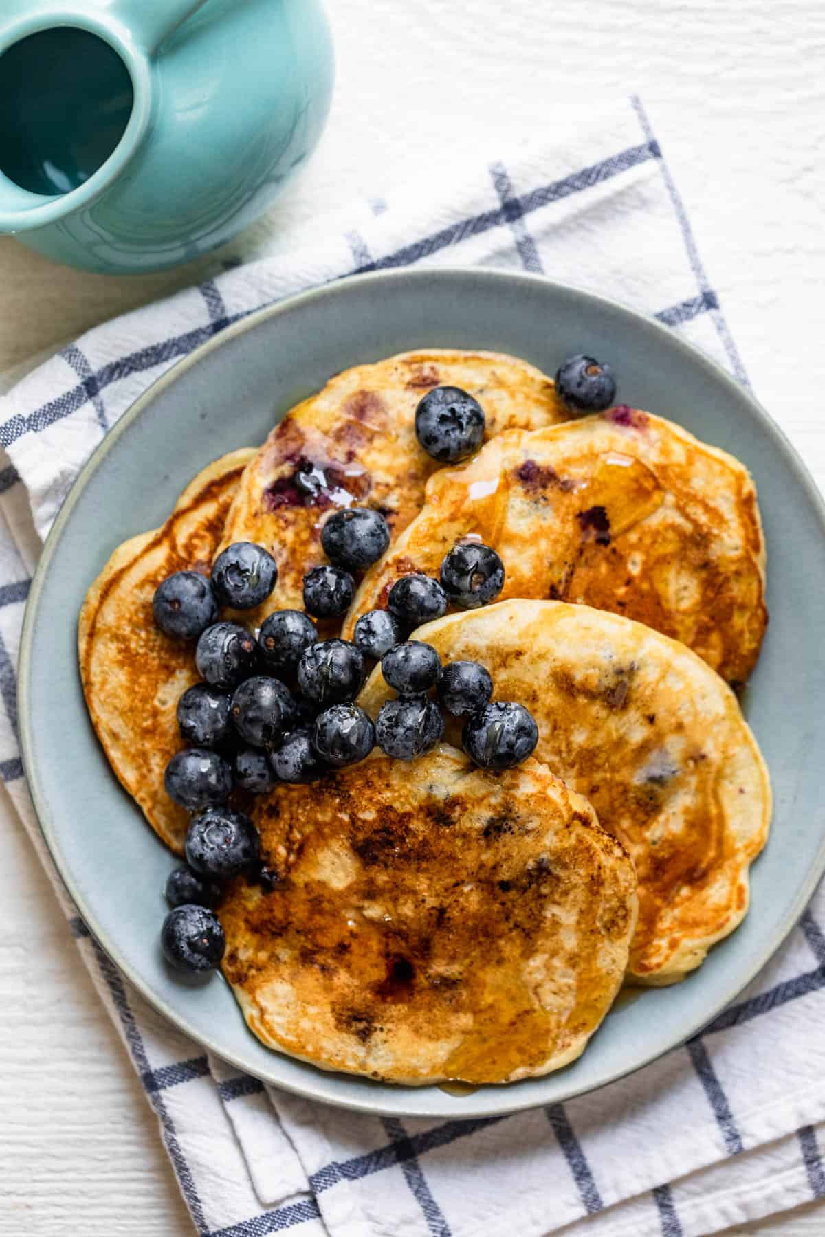 Plate of blueberry pancakes served with maple syrup