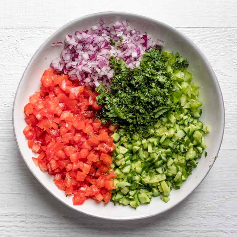 Salad ingredients added on top of the dressing.