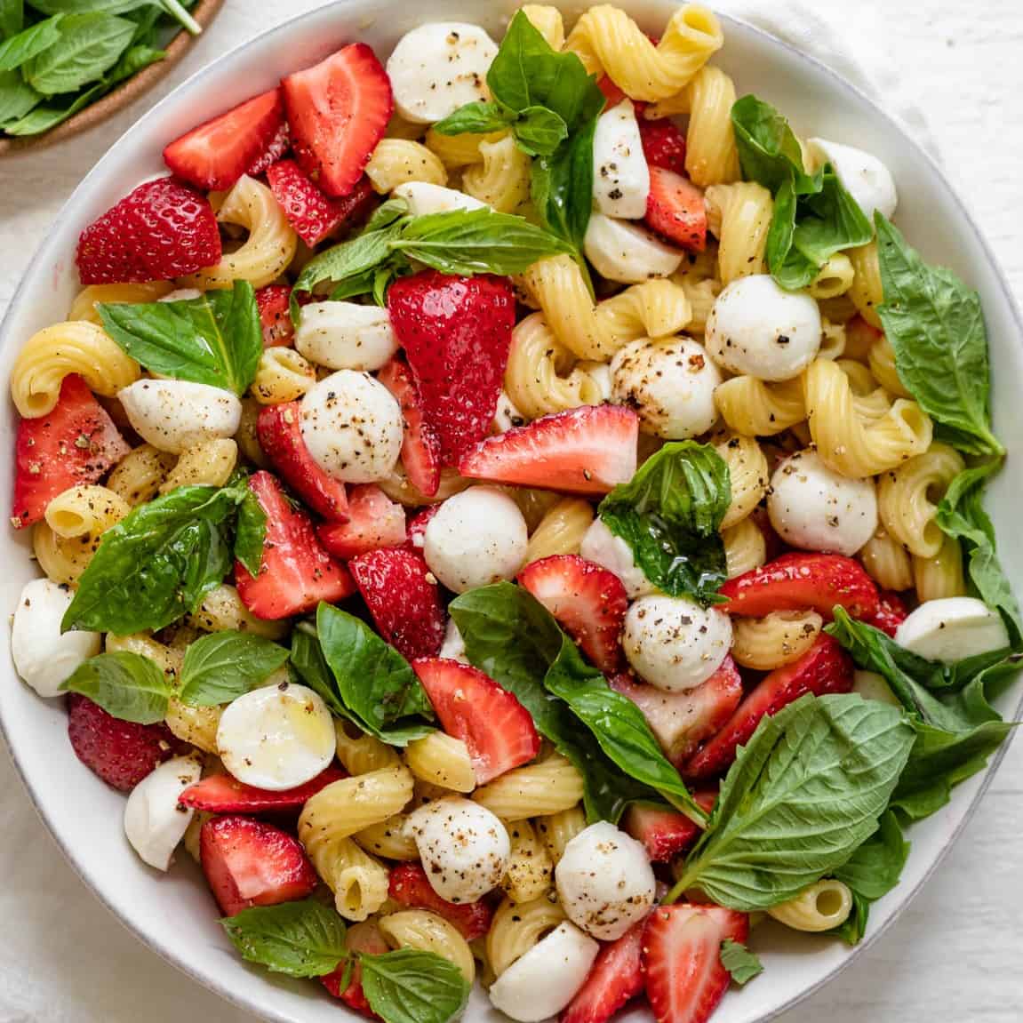 Strawberry caprese salad in a large serving bowl after fully assembled.