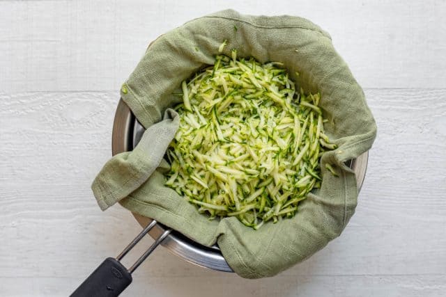 Zucchini grated on a kitchen towel with salt on top