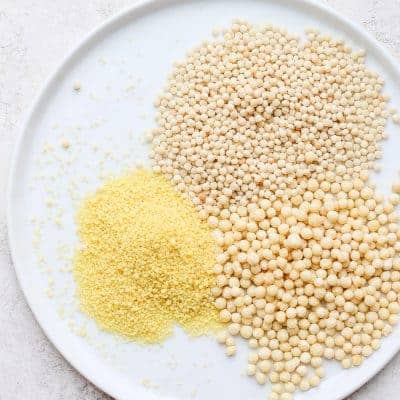 Three types of couscous on a white plate before cooking