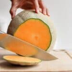 Cutting the top of cantaloupe with sharp knife