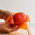 How to peel and seed a tomato - showing peeled tomato on cutting board