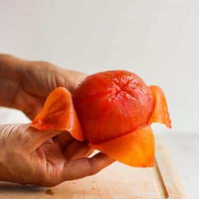 How to peel and seed a tomato - showing peeled tomato on cutting board