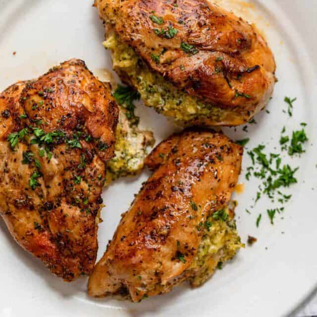 Broccoli and cheese stuffed chicken on a white plate