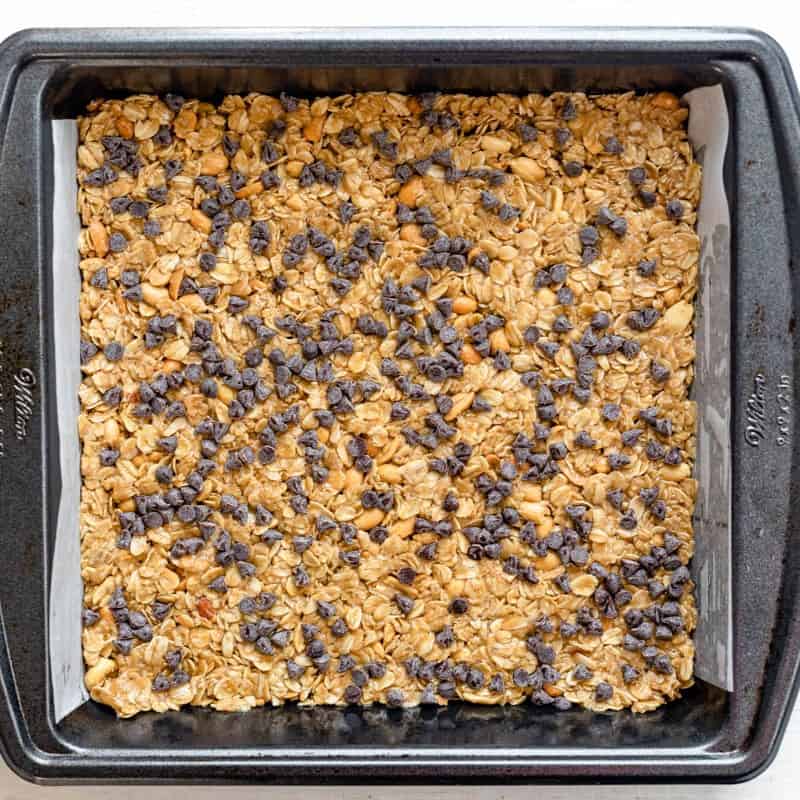 Mixture in a baking tray after baking topped with chocolate chips.