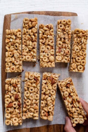 Honey nut cereal bars cut up on a board with parchment paper under